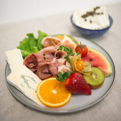 En aptitretande tallrik med saftigt kött, smakrik ost och en färgsprakande variation av frukter.