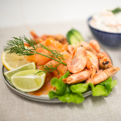 Närbild på en frestande räkskål med saftiga räkor, citronklyftor och gravad lax