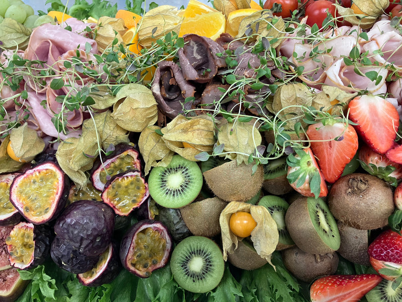 Aptitretande presentation av fikon, skinka och frukter på en stilfull platå