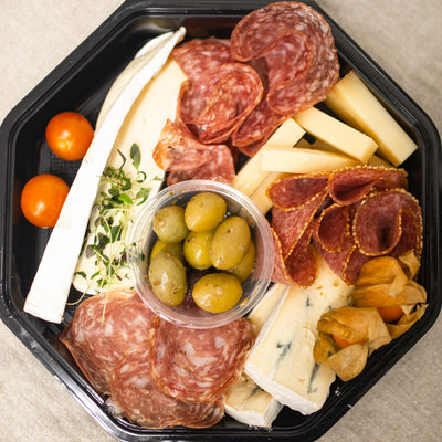 En liten låda fylld med olika frestelser, såsom oliver, chark och ost