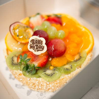 En vacker frukttårta med dekorativa arrangemang av färska frukter på en fluffig tårtbotten